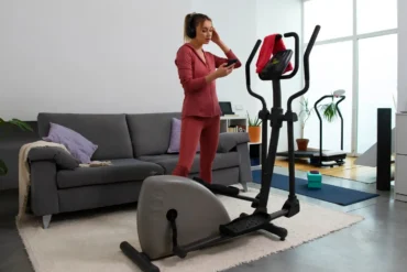 Mulher praticando exercícios em casa usando uma bicicleta ergométrica dobrável, ideal para quem busca praticidade e saúde no dia a dia.