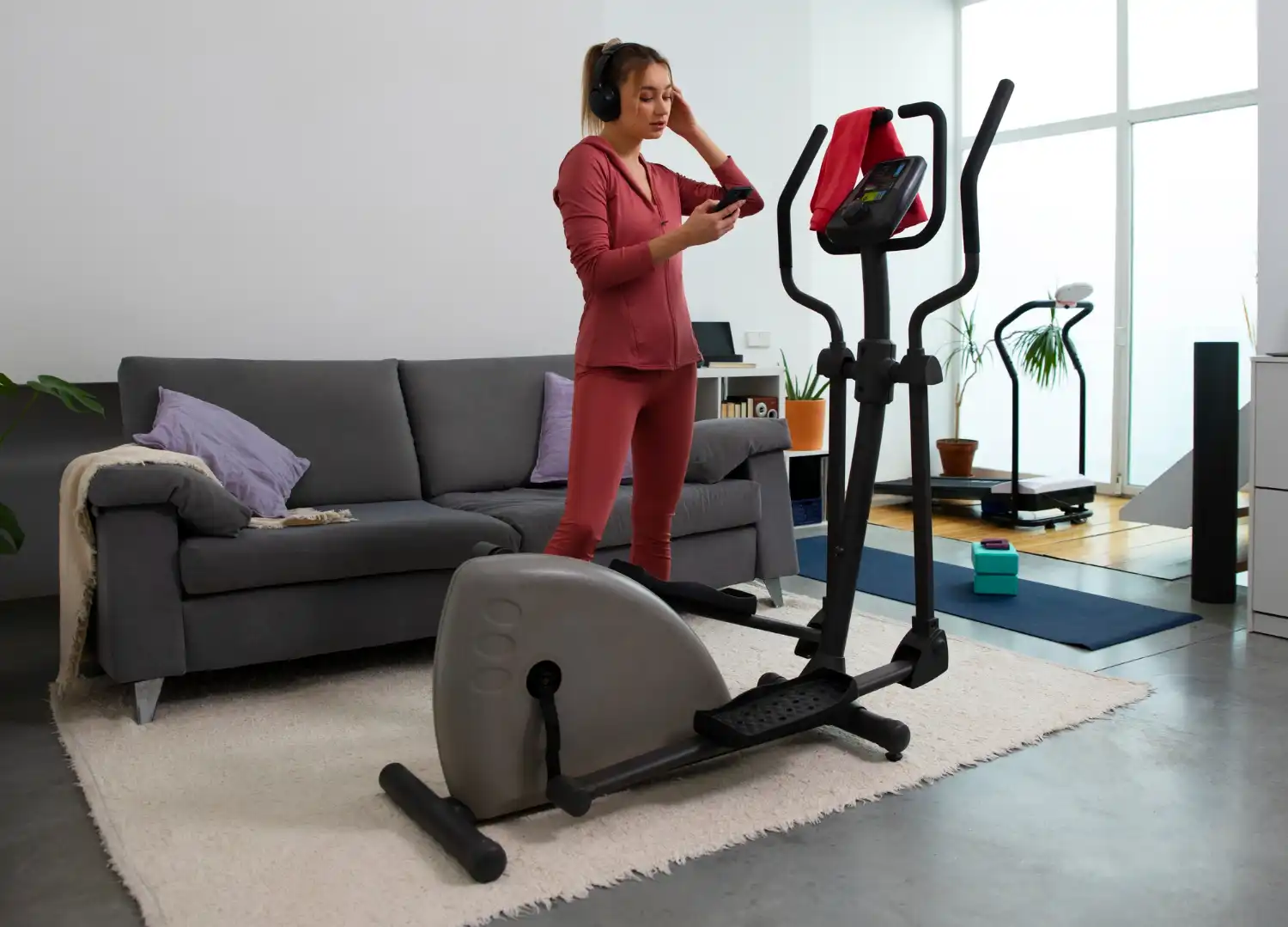 Mulher praticando exercícios em casa usando uma bicicleta ergométrica dobrável, ideal para quem busca praticidade e saúde no dia a dia.